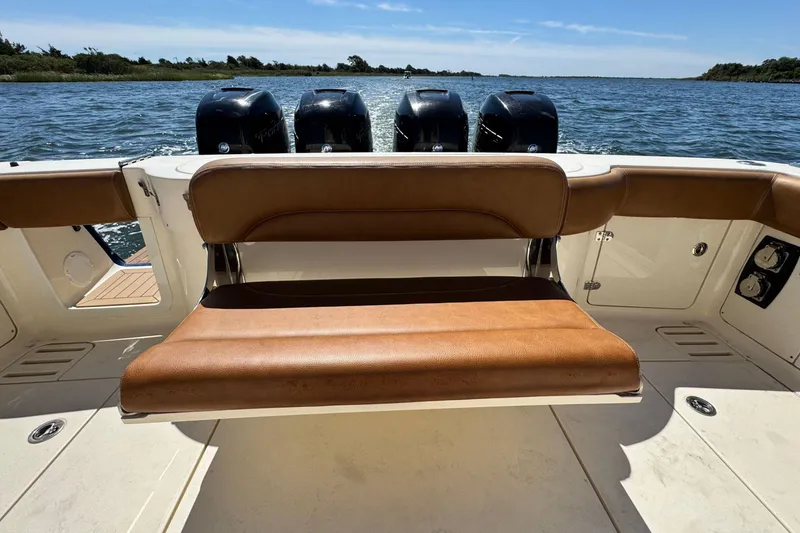 Slide: The Image of 2016 Scout 420 LXF boat with brown seating and four outboard engines on water. - 13