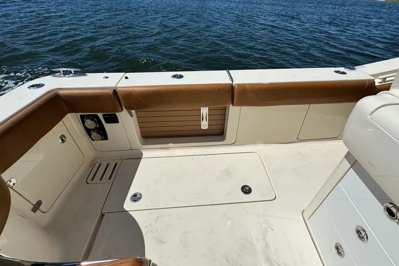 Slide: The Image of 2016 Scout 420 LXF boat deck with brown seating, overlooking the water. - 17