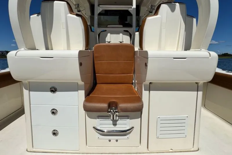 Slide: The Image of 2016 Scout 420 LXF boat interior with brown leather seating and storage compartments. - 19