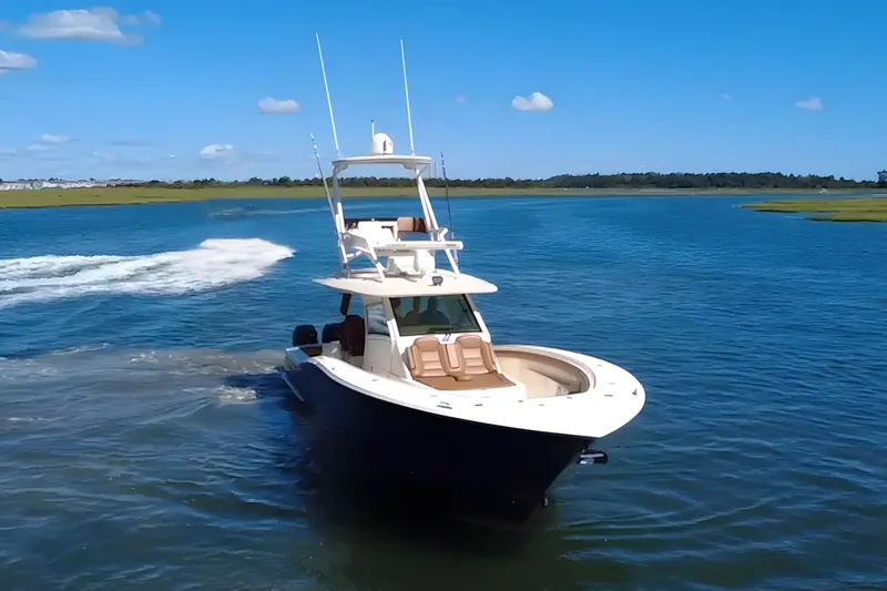 Slide: The Image of 2016 Scout 420 LXF boat cruising on a sunny day in open water. - 2