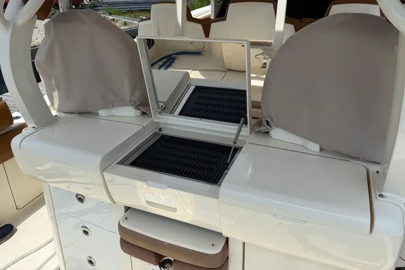 Slide: The Image of 2016 Scout 420 LXF boat interior with covered seating and storage compartments. - 20