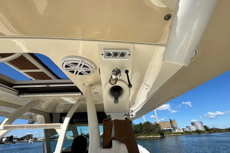 Slide: The Image of 2016 Scout 420 LXF boat interior with speaker and control panel, under clear blue sky. - 23