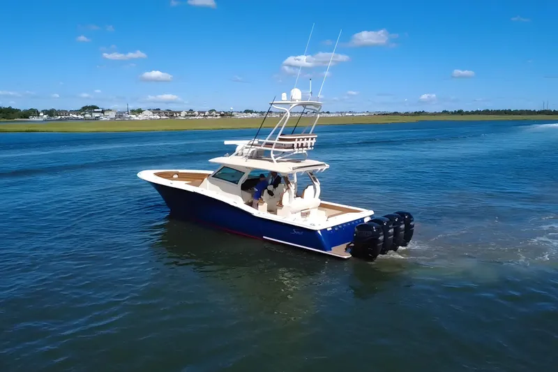 Slide: The Image of 2016 Scout 420 LXF boat cruising on a sunny day with clear blue skies. - 3