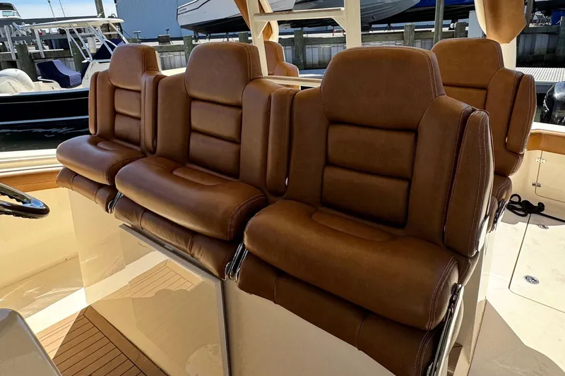 Slide: The Image of Luxurious brown leather seats on a 2016 Scout 420 LXF boat interior. - 30