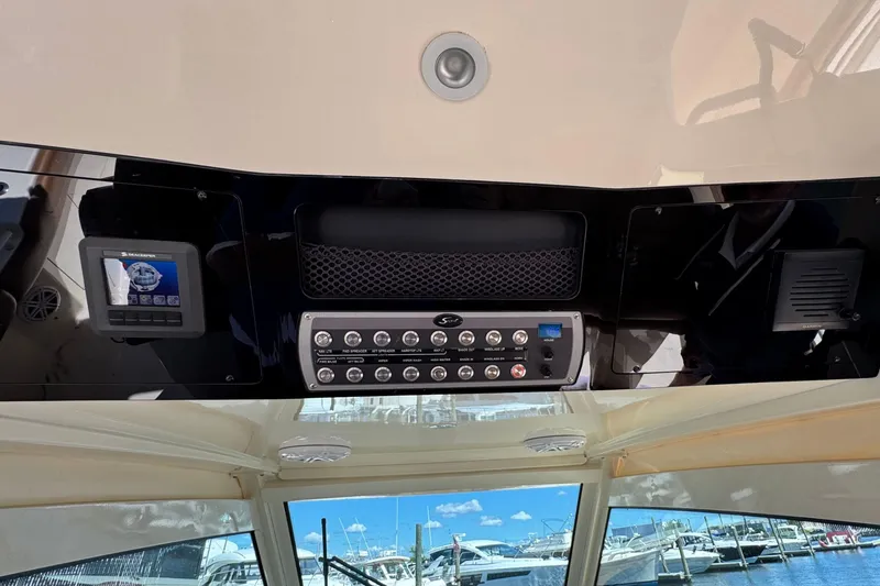 Slide: The Image of 2016 Scout 420 LXF boat dashboard with control panel and marina view. - 36