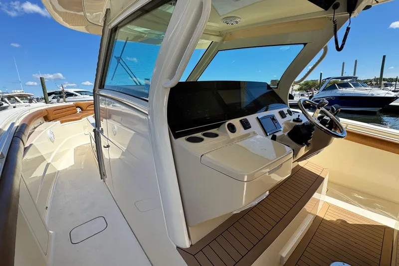 Slide: The Image of 2016 Scout 420 LXF boat interior with helm, steering wheel, and seating area. - 39