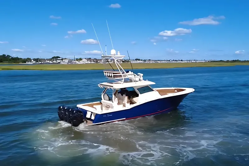 Slide: The Image of 2016 Scout 420 LXF boat cruising on a sunny day with clear blue skies. - 4