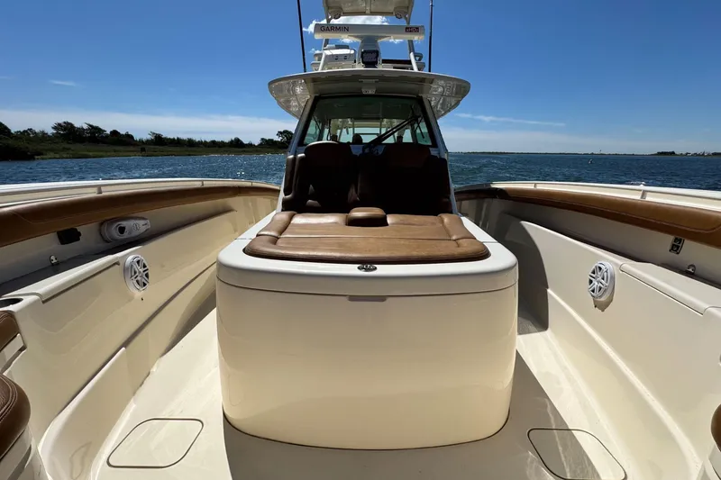 Slide: The Image of 2016 Scout 420 LXF boat interior with seating, on calm water under clear sky. - 42