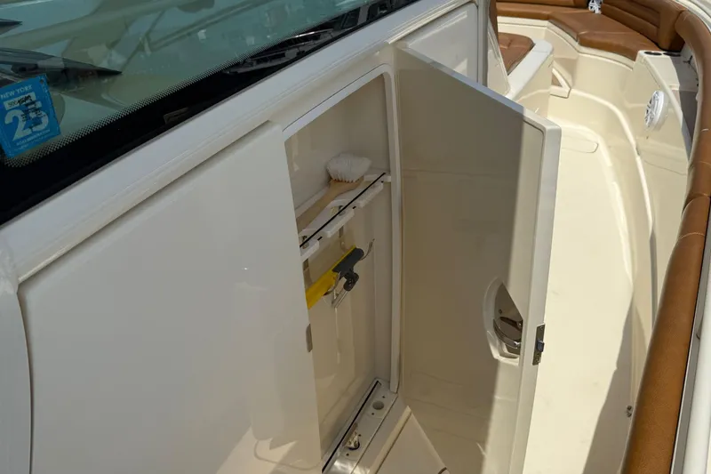 Slide: The Image of 2016 Scout 420 LXF boat interior with open storage compartment and seating area. - 48