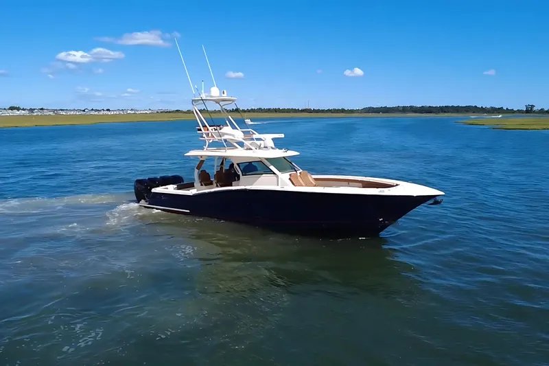 Slide: The Image of 2016 Scout 420 LXF boat cruising on a sunny day in open water. - 5