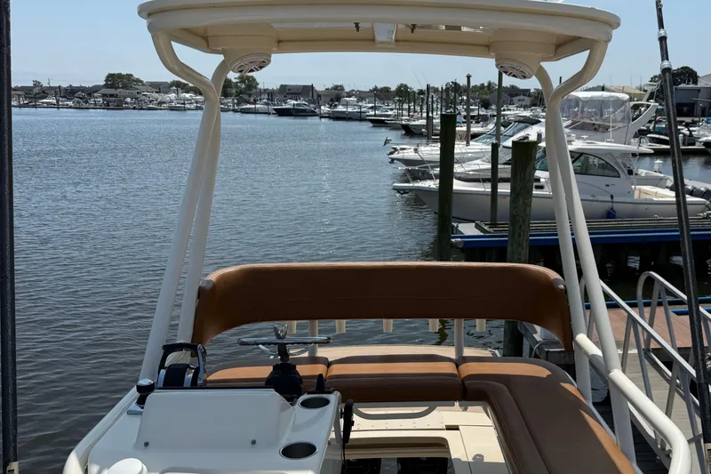 Slide: The Image of 2016 Scout 420 LXF boat docked at marina, featuring spacious seating and helm. - 51