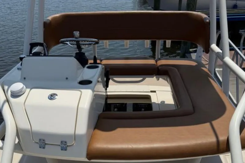 Slide: The Image of 2016 Scout 420 LXF boat helm with brown seating and steering wheel. - 52