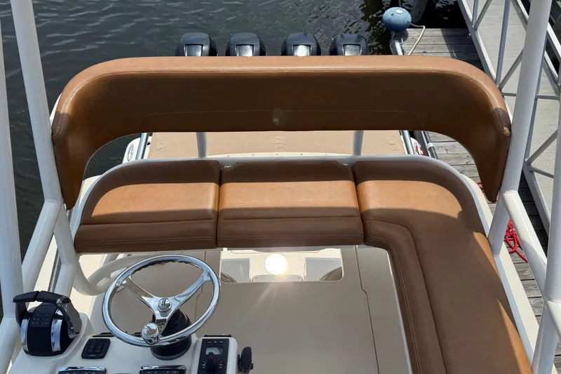 Slide: The Image of 2016 Scout 420 LXF boat helm with brown seating and steering wheel. - 53