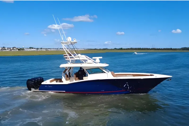 Slide: The Image of 2016 Scout 420 LXF boat cruising on a sunny day in open water. - 6