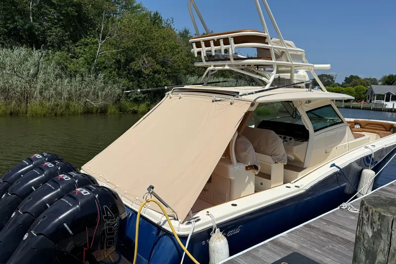 Slide: The Image of 2016 Scout 420 LXF boat docked with multiple outboard engines and canopy. - 64