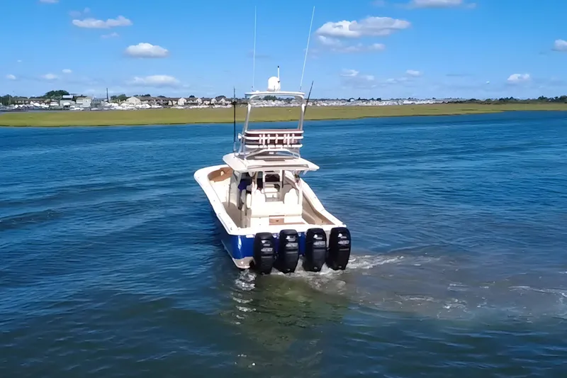 Slide: The Image of 2016 Scout 420 LXF boat cruising on a sunny day with clear blue skies. - 7