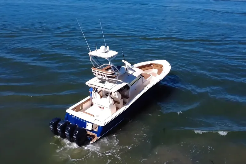 Slide: The Image of 2016 Scout 420 LXF boat cruising on open water, rear view. - 9