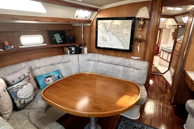 Slide: The Image of Cozy interior of 1991 Catalina 42 MkII sailboat with wooden table and cushioned seating. - 1