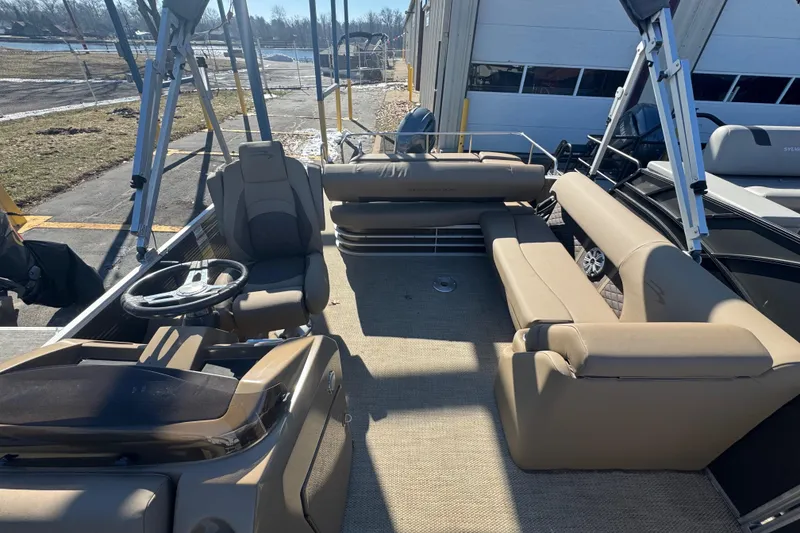 Slide: The Image of 2018 Bennington 23 SSBXP pontoon boat interior with beige seating and steering console. - 10