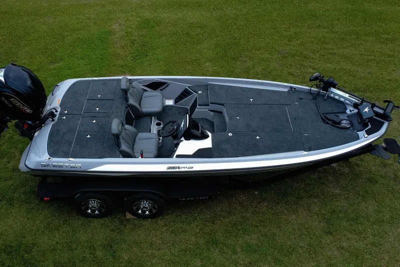 Slide: The Image of 2026 Skeeter ZXR20 SE fishing boat on grass, showcasing sleek design and spacious deck. - 3