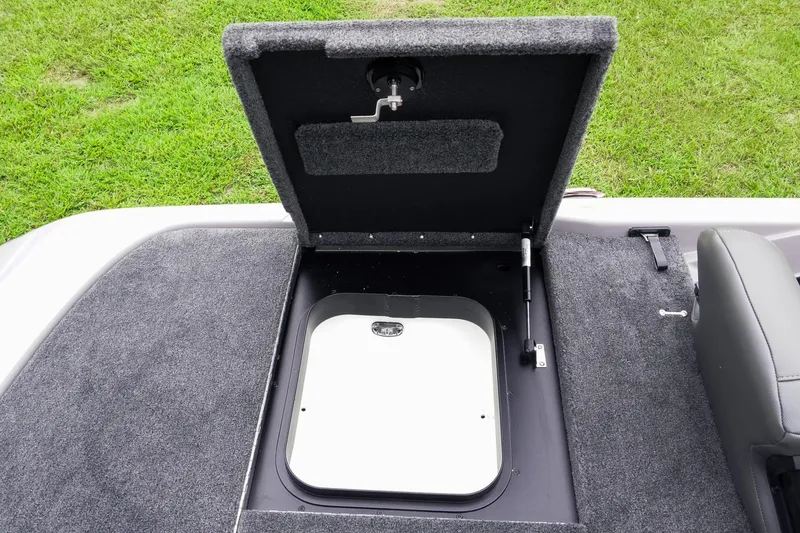 Slide: The Image of Open storage compartment on 2026 Skeeter ZXR20 SE boat, featuring carpeted interior and hydraulic lift. - 41