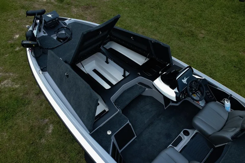 Slide: The Image of 2026 Skeeter ZXR20 SE boat interior with open storage compartments and steering console. - 7