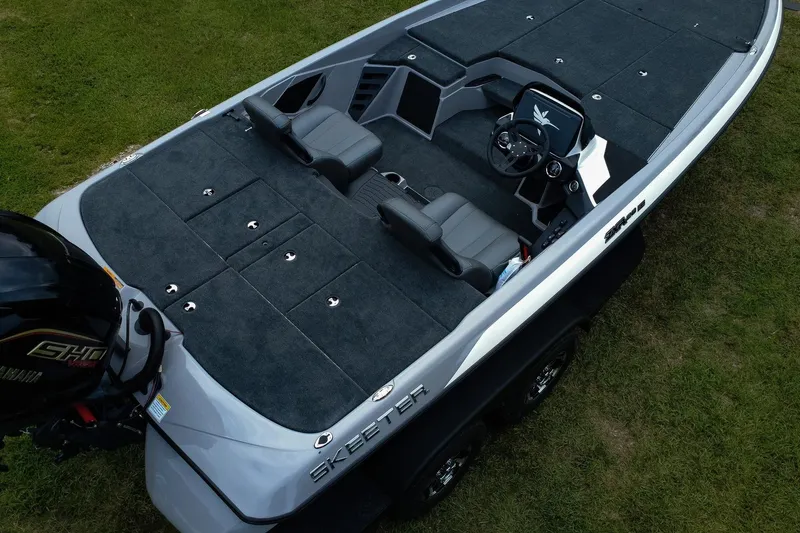 Slide: The Image of 2026 Skeeter ZXR20 SE boat with spacious deck and modern seating on grass. - 9