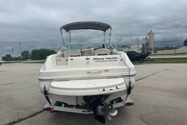 Slide: The Image of 2002 Sea Ray 225 Weekender boat with canopy, parked on concrete surface. - 11