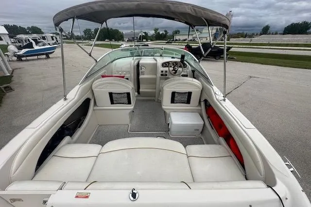 Slide: The Image of 2002 Sea Ray 225 Weekender boat interior with seating, canopy, and dashboard view. - 12