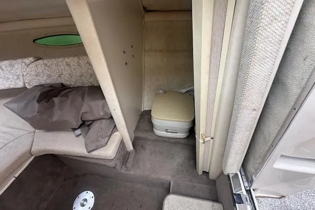 Slide: The Image of Interior cabin of 2002 Sea Ray 225 Weekender boat with compact toilet and seating area. - 14