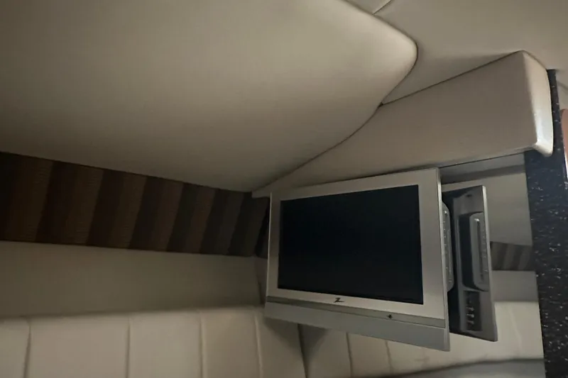 Slide: The Image of Interior of 2005 Formula 280 Sun Sport with mounted TV and cushioned seating. - 16