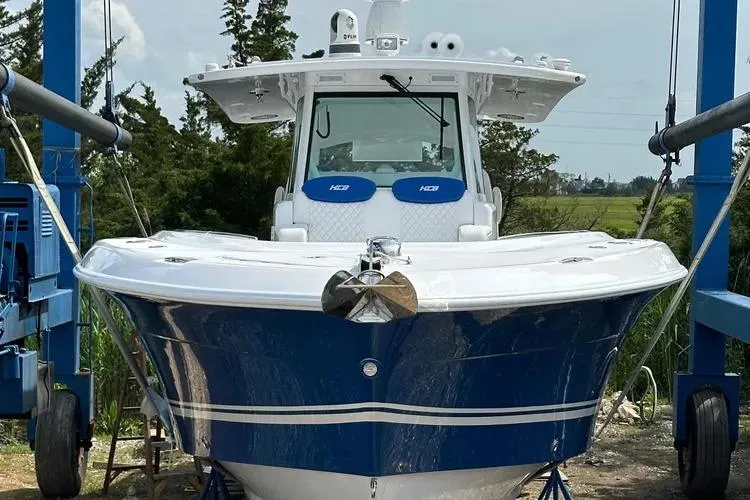 Slide: The Image of 2025 HCB 42 Lujo boat in dry dock, front view, blue and white design. - 11