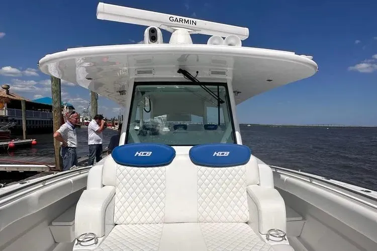 Slide: The Image of 2025 HCB 42 Lujo boat with Garmin equipment, docked by the water under a clear blue sky. - 19
