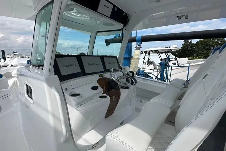 Slide: The Image of 2025 HCB 42 Lujo boat cockpit with Garmin displays and luxurious seating. - 2