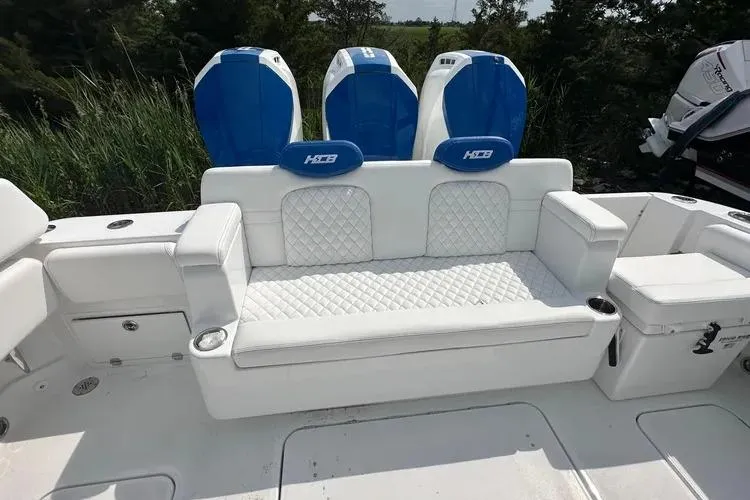 Slide: The Image of 2025 HCB 42 Lujo boat with white seating and blue engine covers. - 5