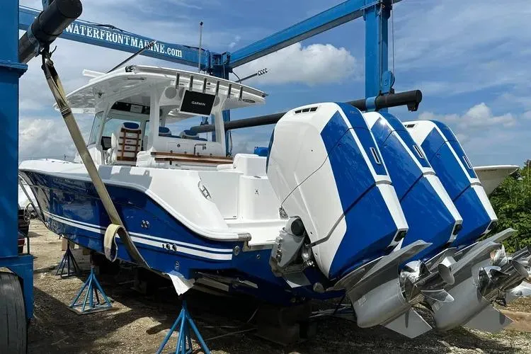 Slide: The Image of 2025 HCB 42 Lujo boat with triple outboard engines on a lift. - 6