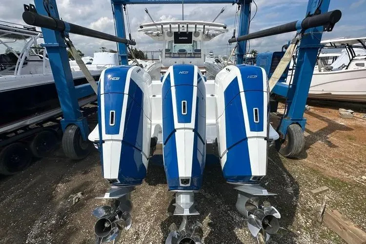 Slide: The Image of 2025 HCB 42 Lujo boat with triple outboard engines in a marina setting. - 7
