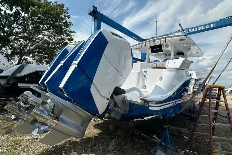 Slide: The Image of 2025 HCB 42 Lujo boat with powerful engines, docked outdoors under a blue sky. - 8
