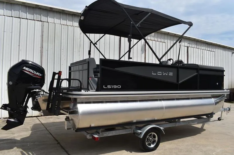 The Image of 2026 Lowe LS 190 pontoon boat with canopy, parked on a trailer. - 0