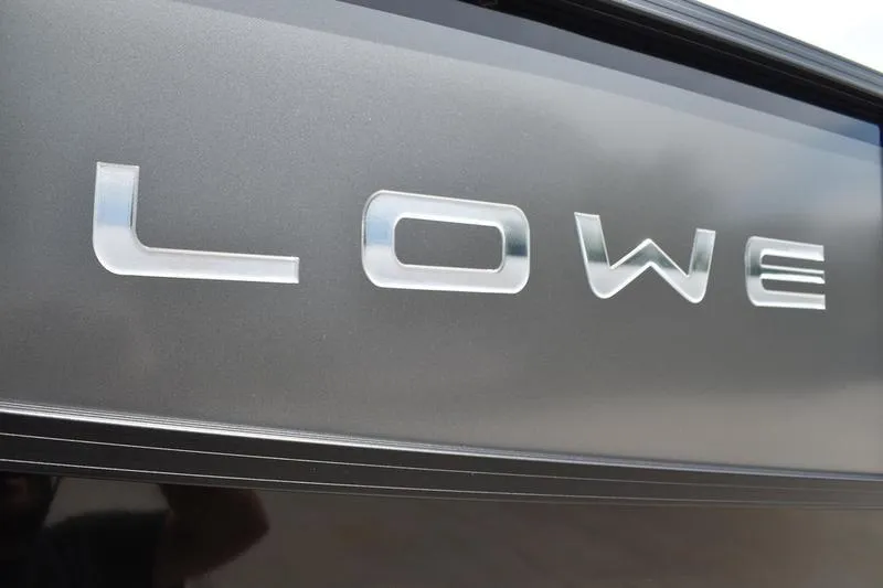 Slide: The Image of 2026 Lowe LS 190 pontoon boat with ladder and trailer, rear view. - 6