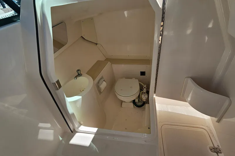 Slide: The Image of 2016 Pursuit DC 265 Dual Console boat interior with compact bathroom amenities. - 20