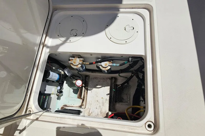 Slide: The Image of 2016 Pursuit DC 265 Dual Console boat compartment with visible wiring and components. - 29