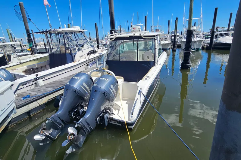 Slide: The Image of 2016 Pursuit DC 265 Dual Console boat docked with twin Yamaha engines. - 31