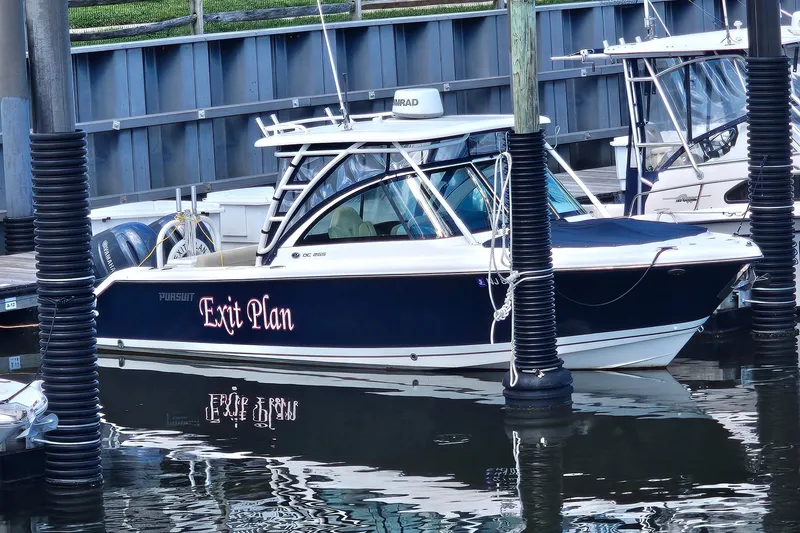 Slide: The Image of 2016 Pursuit DC 265 Dual Console boat named "Exit Plan" docked at marina. - 32