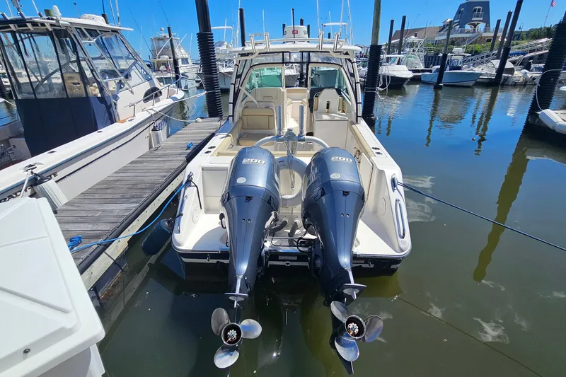 Slide: The Image of 2016 Pursuit DC 265 Dual Console boat docked with twin engines in a marina. - 4