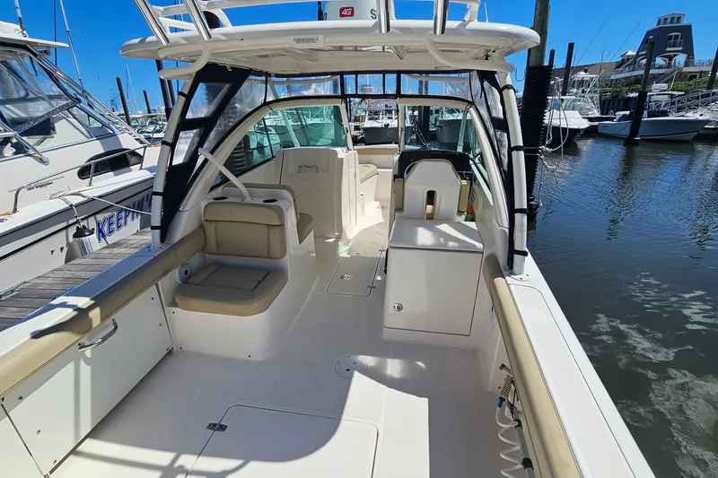 Slide: The Image of 2016 Pursuit DC 265 Dual Console boat docked at marina, featuring spacious seating and helm. - 5