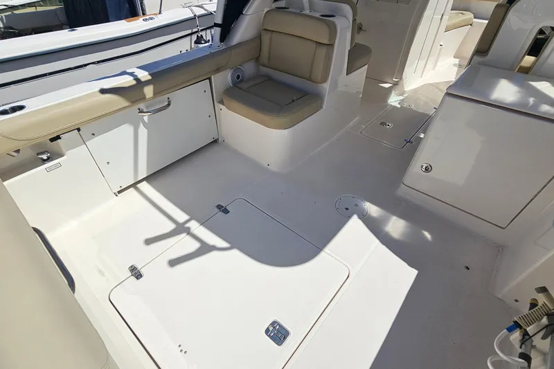 Slide: The Image of 2016 Pursuit DC 265 Dual Console boat interior with seating and storage compartments. - 6