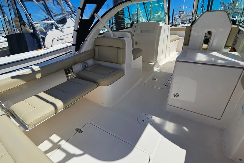 Slide: The Image of 2016 Pursuit DC 265 Dual Console boat interior with beige seating and sleek design. - 7
