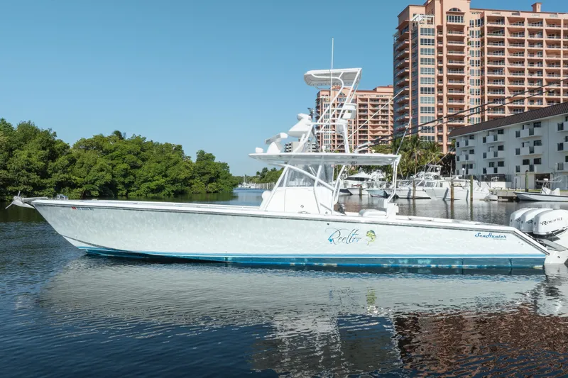 Slide: The Image of 2009 SeaHunter 40 boat docked near waterfront buildings and lush greenery. - 11