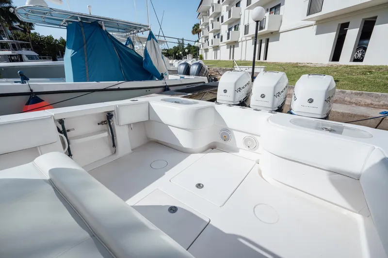 Slide: The Image of 2009 SeaHunter 40 boat interior with triple outboard engines, docked near modern buildings. - 16